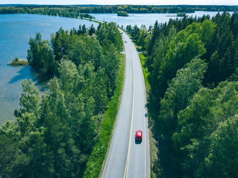 Aerial,View,Of,Road,With,Cars,In,Green,Woods,By